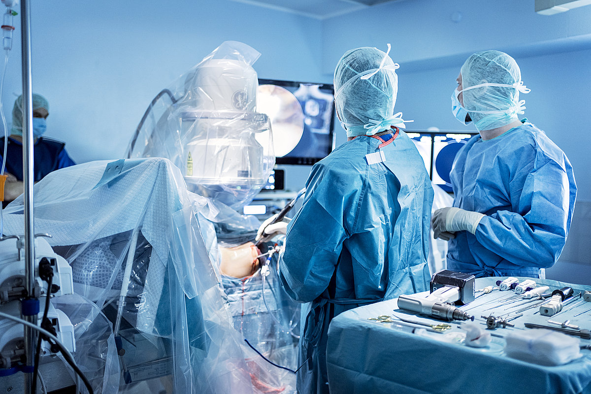 Im Operationssaal: zwei Personen in OP-Kleidung, viel OP-Equipment