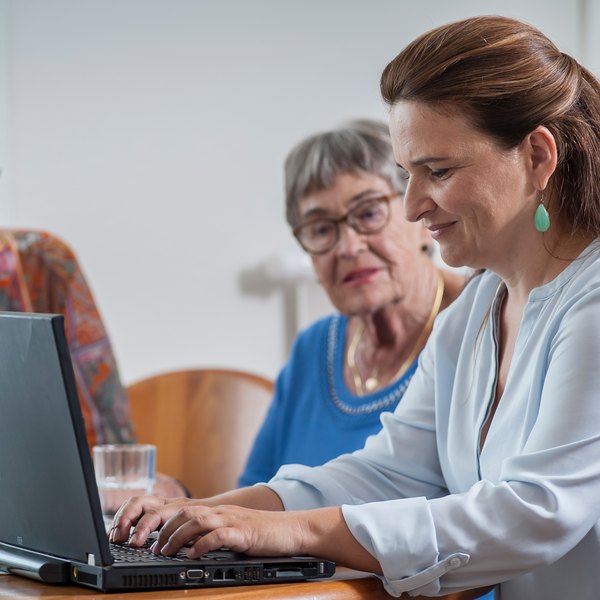 Ärztin am Laptop mit älterer Damen, die auf den Bildschirm schaut